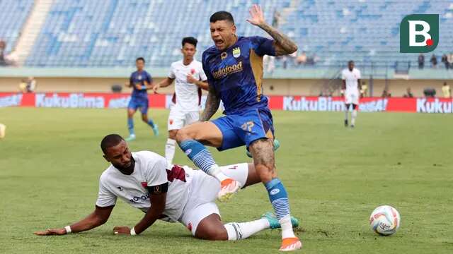 Pemian Persib Bandung, Ciro Alves (kanan) berebut bola dengan pemain PSM Makassar, Yuran Fernandes pada laga Piala Presiden 2024 di Stadion Si Jalak Harupat, Bandung, Jumat (19/07/2024). (Bola.com/Abdul Aziz)