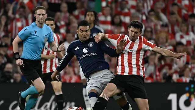 Gelandang MU, Casemiro (kiri), mendapatkan tekel dari pemain Athletic Bilbao, Dani Vivian, pada leg 1 semifinal Liga Europa 2024/2025 di Stadion San Mames, Jumat (2/5/2025) dini hari WIB. (ANDER GILLENEA / AFP)