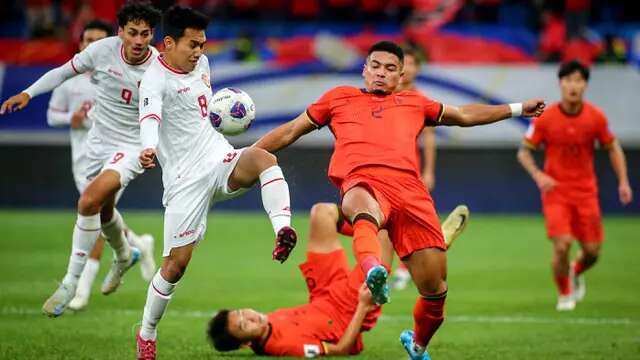 Pemain Timnas Indonesia, Witan Sulaeman (kiri) berebut bola dengan pemain China, Jiang Guangtai (kanan) saat laga lanjutan putaran ketiga Grup C Kualifikasi Piala Dunia 2026 di Qingdao Youth Stadium, Qingdao, China, Selasa (15/10/2024). (AFP)