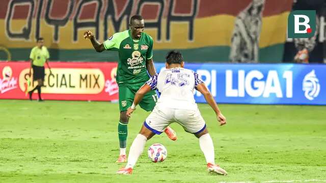 Striker Persebaya, Flavio Silva, mencoba melewati adangan pemain PSIS, Syiha Buddin, pada lanjutan BRI Liga 1 2024/2025 di Stadion Gelora Bung Tomo, Surabaya, Rabu (12/3/2025) malam WIB. (Bola.com/Aditya Wany)