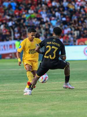 Winger Semen Padang, Irkham Mila (Kuning) mencoba menghindari hadangan dari pemain Maluku United, Yance Sayuri (23). (Bola.com/Nandang Permana)
