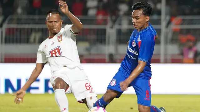 Gelandang Arema, Arkhan Fikri berduel dengan gelandang Malut United, Manahati Lestusen. (Bola.com/Iwan Setiawan)