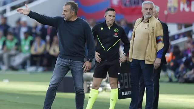 Gaya berbusana santai pelatih Barcelona, Hansi Flick, saat timnya bersua Real Madrid pada laga pekan ke-35 La Liga 2024/2025 di Estadi Olimpic Lluis Companys, Barcelona, Minggu (11/5/2025) malam WIB. (AP Photo/Joan Monfort)