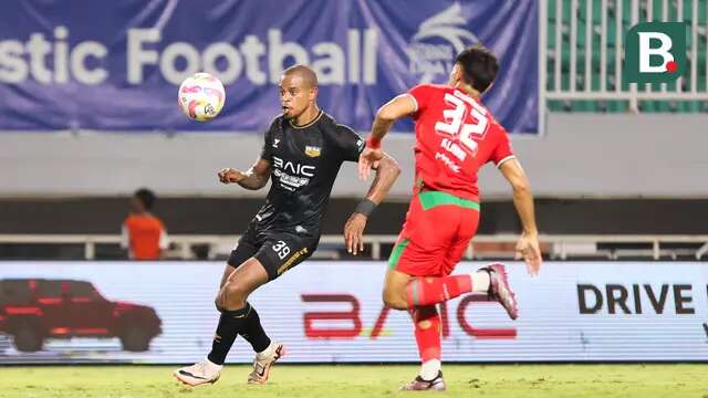 Pemain Dewa United, Alex Martins (kiri), dijaga ketat oleh pemain Persebaya Surabaya, Riswan Lauhin, dalam pertandingan Dewa United melawan Persebaya Surabaya pada pekan ke-24 BRI Liga 1 di Stadion Pakansari, Kabupaten Bogor, Jumat (21/2/2025) malam WIB. (Bola.com/Abdul Aziz)