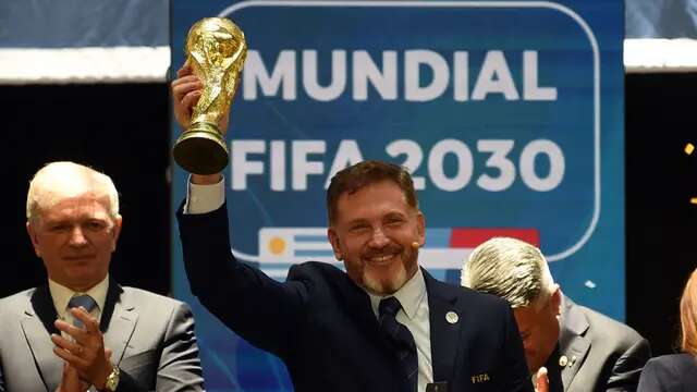 Presiden Paraguay, Alejandro Dominguez mengangkat replika trofi Piala Dunia saat penunjukkan Argentina, Paraguay, dan Uruguay sebagai negara tuan rumah Piala Dunia FIFA 2030 selama Kongres virtual FIFA di Luque, Paraguay pada 11 Desember 2024. (AFP/Daniel Duarte)