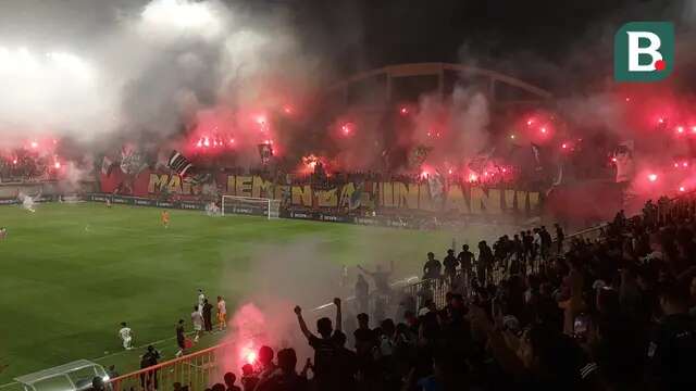 Suporter PSS Sleman menyalakan flare saat bersua Persija Jakarta pada laga pekan ke-33 BRI Liga 1 musim ini di Stadion Maguwoharjo, Sleman, Sabtu (17/5/2025) malam WIB. Meski sempat dihentikan gara-gara asap flare, PSS berhasil menang 2-1 atas Persija. (Bola.com/Ana Dewi)