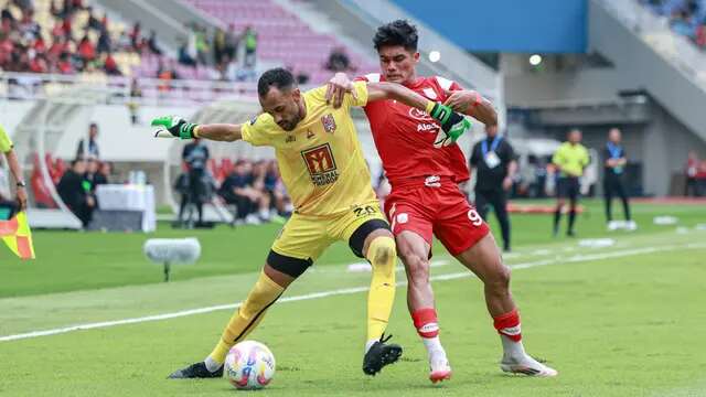 Striker Persis Solo, Ramadhan Sananta, saat mencoba merebut bola dari penjagaan kiper Malut United, Wagner Augusto, pada pertandingan pekan ke-28 BRI Liga 1 2024/2025 di Stadion Manahan, Solo, Sabtu (12/4/2025). (Bola.com/Radifa Arsa)