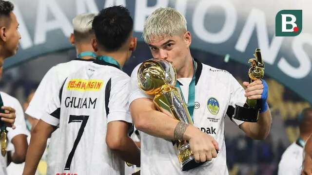 Pemain PSIM Yogyakarta, Rafinha mencium trofi Pegadaian Liga 2 2024/2025 setelah timnya berhasil menang atas Bhayangkara FC dalam laga final yang berlangsung di Stadion Manahan, Solo, Jawa Tengah, Rabu (26/02/2025). (Bola.com/Abdul Aziz)