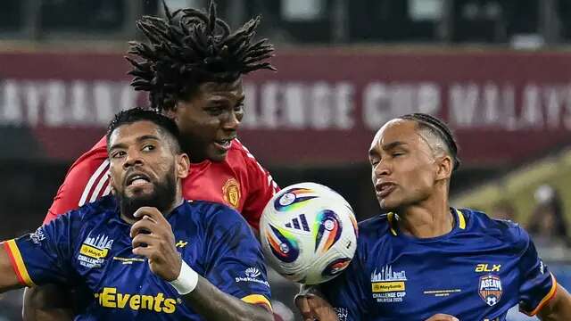 Pemain Manchester United, Patrick Dorgu berdel dengan dua pemain ASEAN All Stars, Kealey Adamson (kanan) dan Mo Kan dalam laga eksebisi di Stadion Bukit Jalil, Kuala Lumpur, Malaysia, Rabu (28/5/2025). (AFP/Mohd Rasfan).
