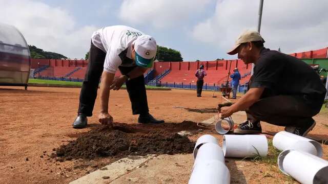 Pekerja sedang melakukan pemasangan biopori di Stadion Brawijaya. (Gatot Susetyo/Bola.com)