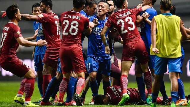 Gelandang Shanghai SIPG, Oscar tergeletak di lapangan saat dikerumuni pemain Guangzhou R&F pada pertandingan Liga Super China di Guangzhou, Guangdong, China selatan, (18/6). Pertandingan ini berakhir dengan skor 1-1. (AFP Photo/Str/China Out)
