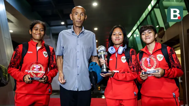 Pemain Timnas Indonesia, Laita Roati (kiri), Viny Silfianus (kedua kanan), Reva Octaviani (kanan), dan pelatih Satoru Mochizuki (kedua kiri) berpose dengan membawa trofi Piala AFF Wanita 2024 dan penghargaan individu (kiper terbaik dan pemain terbaik) saat mendarat di Gedung VVIP Terminal 3 Bandara Soekarno Hatta, Tangerang, Jumat (06/12/2024). (Bola.com/Bagaskara Lazuardi)