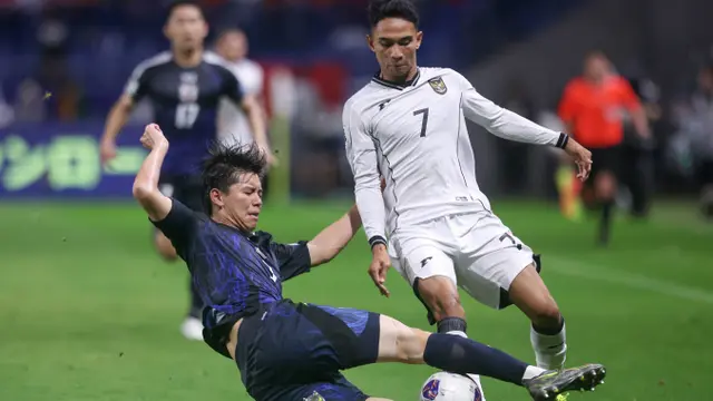 Gelandang Timnas Indonesia, Marselino Ferdinan mendapatkan tekel keras dari bek Timnas Jepang, Kota Takai dalam laga terakhir Grup C putaran ketiga Kualifikasi Piala Dunia 2026 di Suita City Football Stadium, Selasa (10/6/2025). (AFP/Paul Miller).