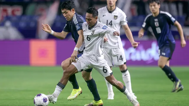 Gelandang Timnas Indonesia, Beckham Putra mendapatkan penjagaan ketat dari gelandang Timnas Jepang, Wataru Endo dalam laga terakhir Grup C putaran ketiga Kualifikasi Piala Dunia 2026 di Suita City Football Stadium, Selasa (10/6/2025). (AFP/Paul Miller).