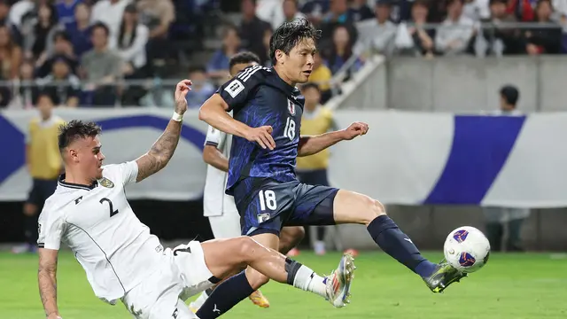 Bek Timnas Indonesia, Mees Hilgers (kiri), mencoba menghentikan pergerakan pemain Jepang, Shuto Machino, pada Kualifikasi Piala Dunia 2026 di Panasonic Stadium, Osaka, Selasa (10/6/2025) sore WIB. (STR / JIJI PRESS / AFP)