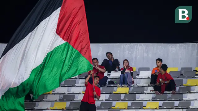 Seorang suporter Indonesia mengibarkan bendera Palestina saat laga kedua Grup A Piala Dunia U-17 2023 antara Timnas Indonesia U-17 menghadapi Timnas Panama U-17 di Stadion Gelora Bung Tomo (GBT), Surabaya, Senin (13/11/2023). (Bola.com/Bagaskara Lazuardi)