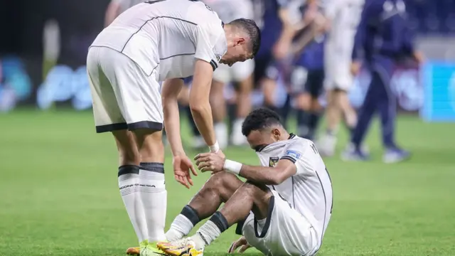 Bek Indonesia, Jay Noah Idzes (kiri), menghibur rekan setimnya, Yance Sayuri, setelah kekalahan mereka dalam pertandingan kualifikasi Piala Dunia Grup C antara Jepang dan Indonesia di Osaka pada 10 Juni 2025. (PAUL MILLER/AFP)