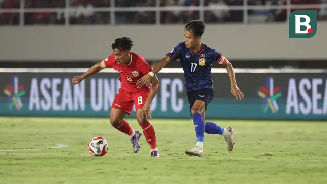 Pemain Timnas Indonesia, Arkhan Fikri berebut bola dengan pemain Laos, Bounphachan Bounkong pada laga lanjutan Grup B Piala AFF 2024 di Stadion Manahan, Solo, Jawa Tengah, Kamis (12/12/2024). (Bola.com/Abdul Aziz)