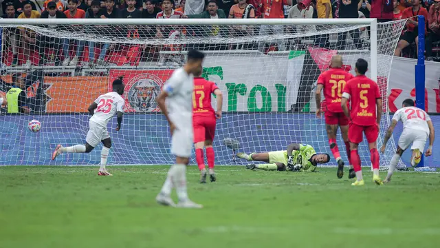 Kiper Persija Jakarta, Carlos Eduardo Saores (kanan) gagal menghalau bola tendangan penalti pemain Persis Solo, Moussa Sidibe pada laga lanjutan BRI Liga 1 2024/2025 di Jakarta International Stadium (JIS), Jakarta Utara, Sabtu (24/08/2024). (Bola.com/Bagaskara Lazuardi)