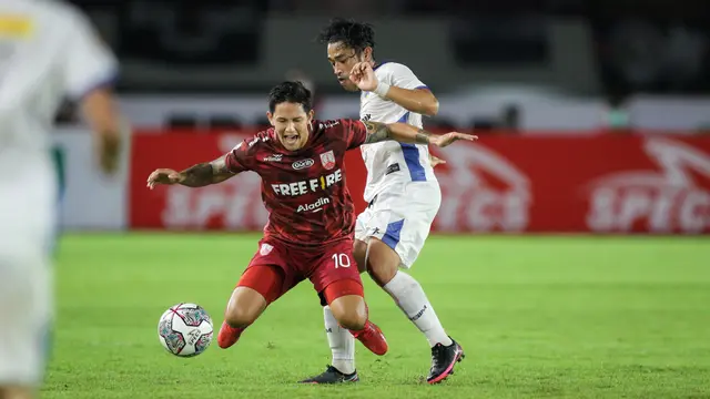 Pemain Persis Solo, Irfan Haary Bachdim (kiri) berebut bola dengan pemain PSIM Yogyakarta, Beny Wahyudi saat matchday ke-8 Grup C Liga 2 2021 antara Persis Solo melawan PSIM Yogyakarta di Stadion Manahan, Solo, Senin (15/11/2021). (Bola.com/Bagaskara Lazuardi)