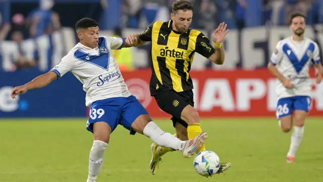 Pemain depan Velez Sarsfield #39, Imanol Machuca, dan pemain bertahan Penarol #20, Pedro Milans, berebut bola selama pertandingan babak pertama penyisihan grup Copa Libertadores antara Velez Sarsfield dari Argentina dan Penarol dari Uruguay di stadion Jose Amalfitani di Buenos Aires pada tanggal 2 April 2025. (JUAN MABROMATA/AFP)