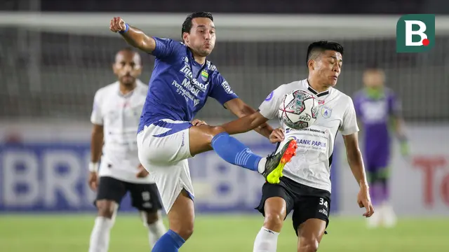 Pemain Persib Bandung, Ezra Walian (kiri) berebut bola dengan pemain Persipura Jayapura, Takuya Matsunaga dalam laga pekan ke-10 BRI Liga 1 2021/2022 di Stadion Manahan, Solo, Sabtu (30/10/2021). (Bola.com/Bagaskara Lazuardi)