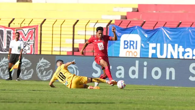 Bek Malut United, Wahyu Prasetyo mencoba mengindari tekel dari gelandang Semen Padang, Bruno Dybal dalam laga lanjutan BRI Liga 1 2024/2025 di Stadion Sultan Agung, Bantul, Jumat (13/9/2024). (Dok. Malut United)