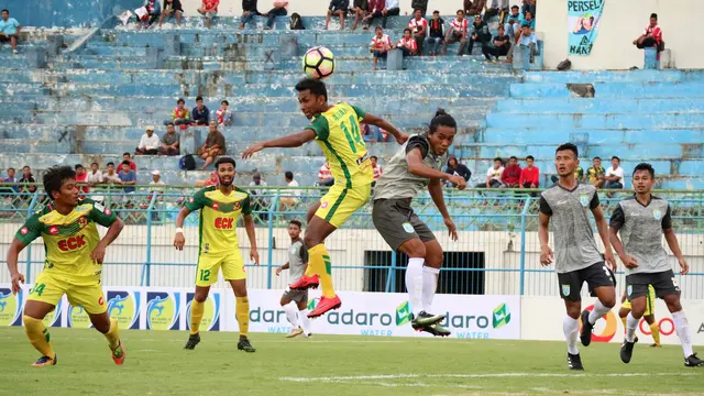 Bek Persela, Samsul Arifin, dan pemain Kedah FA, M. Akram Mahinan, berduel memperebutkan bola di Stadion Gelora Bangkalan, Bangkalan (8/1/2018). (Bola.com/Aditya Wany)