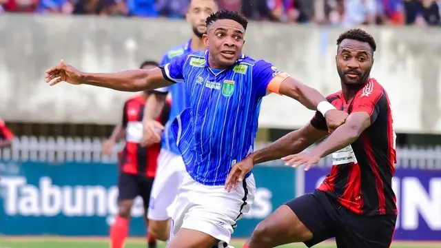 Kapten Persibo Bojonegoro, Osas Saha mendapatkan kawalan dari pemain Persipura Jayapura, Yeter Amohoso dalam play-off degradasi Pegadaian Liga 2 2024/2025 di Stadion Mandala, Jayapura, Jumat (28/2/2025). (Dok. Persibo).