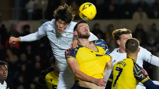 Pemain Arsenal Takehiro Tomiyasu (kiri) melompat untuk memperebutkan bola dengan pemain Oxford United Elliott Moore pada pertandingan sepak bola Piala FA di Stadion Kassam, Oxford, Inggris, 9 Januari 2023. Arsenal menang 3-0. (AP Photo/Frank Augstein)