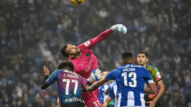 Penjaga gawang Chaves asal Brasil #31, Rodrigo Moura Nascimento, membelokkan bola selama pertandingan sepak bola Liga Portugal antara FC Porto dan GD Chaves di stadion Dragao di Porto pada 29 Desember 2023. (MIGUEL RIOPA/AFP)