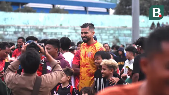 Julian Guevara jadi salah satu pemain yang diburu foto bersama oleh Aremania usai pertandingan uji coba antara Arema FC vs NZR di Stadion Gajayana, Malang, Sabtu (6/7/2024). (Bola.com/Iwan Setiawan)
