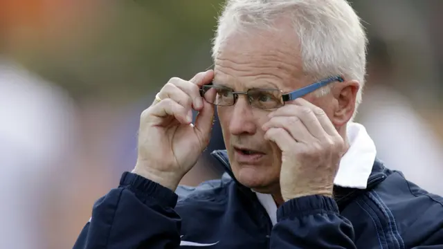 Foppe de Haan, pelatih junior berkebangsaan Belanda menyesuaikan kacamatanya saat latihan melawan timnas junior di Katwijk 11 Mei 2006. Pertandingan berakhir 0-0 setelah timnas tampil lemah. (FOTO AFP: MAARTJE BLIJDENSTEINMAARTJE BLIJDENSTEIN/AFP)