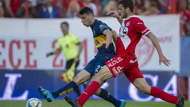 Penyerang Boca Juniors, Jonathan Calleri (kiri), melepaskan tembakan melewati bek Argentinos Juniors, Patricio Matricardi, untuk mencetak gol ketiga tim dalam pertandingan Divisi Pertama Argentina di Stadion Diego Armando Maradona, pada 19 September 2015. (ALEJANDRO PAGNIALEJANDRO PAGNI /AFP)