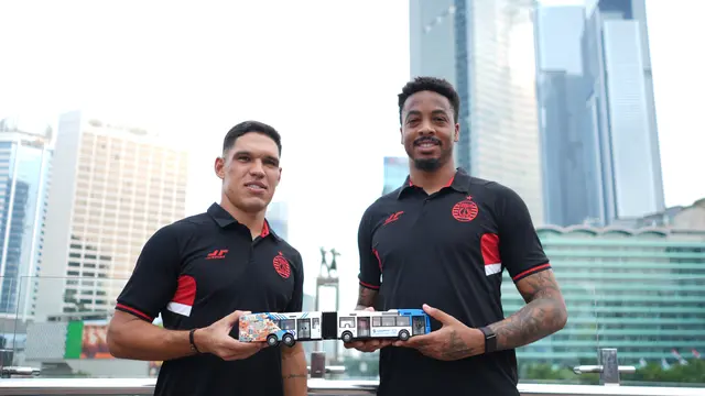 Dua pemain asing Persija Jakarta, Van Basty Sousa dan Carlos Eduardo, memamerkan miniatur bus Transjakarta dengan nuansa Persija Jakarta di bagian belakang bus. Persija Jakarta dan TransJakarta bersinergi untuk Kota Jakarta. (Dok. Persija Jakarta)