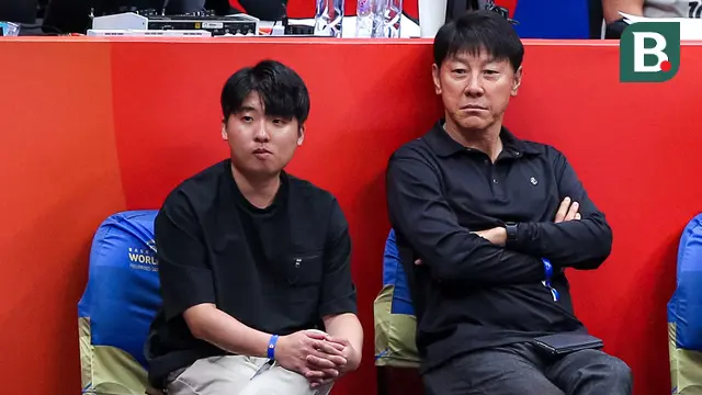 Pelatih Timnas Indonesia, Shin Tae-yong (kanan) berbincang dengan penerjemahnya Jeong Seok-seo saat menonton laga Grup H Piala Dunia FIBA 2023 antara Kanada melawan Latvia di Indonesia Arena, Senayan, Jakarta, Selasa (29/08/2023). (Bola.com/Bagaskara Lazuardi)