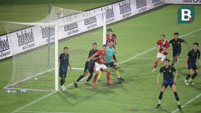 Penyerang Bali United, Boris Kopitovic dikawal ketat pemain PSIM Yogyakarta dalam laga uji coba di Stadion Dipta pada Sabtu malam (26/7/2025). (Bola.com/Alit Binawan)