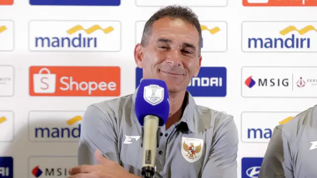 Pelatih Timnas Indonesia U-23 Gerald Vanenburg tersenyum saat menghadiri sesi pemberian keterangan resmi jelang laga ASEAN U23 Championship 2025 melawan Brunei Darussalam di Stadion Utama Gelora Bung Karno, Jakarta pada Senin (14/7/2025). (Bola.com/Abdul Aziz)