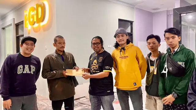 Cak Cong (tiga dari kiri) dan Bonek memberi memberi santunan kepada keluarga korban. (Bola.com/Aditya Wany)