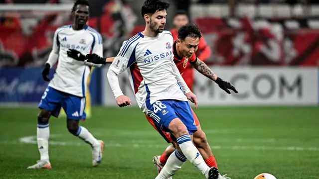 Sandy Walsh (tengah) dari Yokohama F. Marinos berebut bola dengan Feng Jin (kanan) dari Shanghai Port dalam pertandingan Liga Champions AFC antara Yokohama F. Marinos dari Jepang dan Shanghai Port FC dari China di Shanghai pada 19 Februari 2025. (AFP)