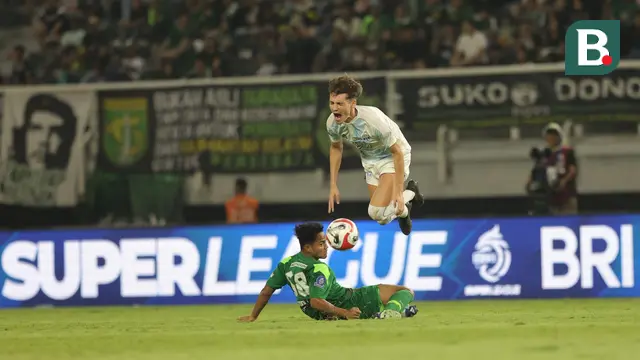 Penyerang PSIM Yogyakarta, Deri Corfe mendapatkan tekel keras dari gelandang Persebaya Surabaya, Toni Firmansyah dalam laga pekan pertama BRI Super League di Stadion Gelora Bung Tomo, Surabaya, Jawa Timur, Jumat (8/8/2025) malam. (Bola.com/Abdul Aziz)