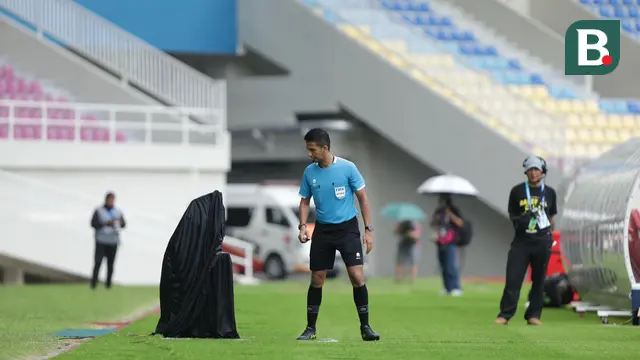 Wasit Thoriq Alkatiri meninjau ulang tayangan video assistant referee (VAR) yang diuji coba pada laga final EPA Liga 1 U-20 2023/2024 di Stadion Manahan, Solo, Kamis (7/3/2042). (Bola.com/Radifa Arsa)