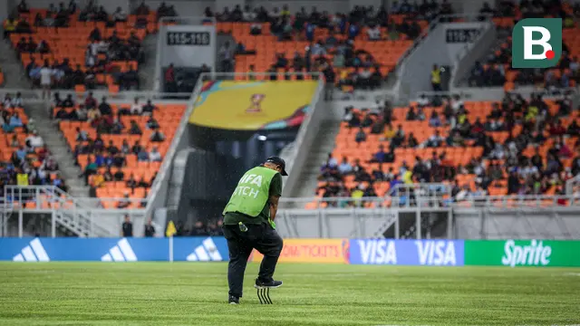 Petugas mengecek rumput setelah air yang menggenangi lapangan Jakarta International Stadium (JIS) akibat hujan deras jelang laga perempat final Piala Dunia U-17 2023 antara Timnas Brasil U-17 melawan Timnas Argentina U-17, Jumat (24/11/2023). (Bola.com/Bagaskara Lazuardi)