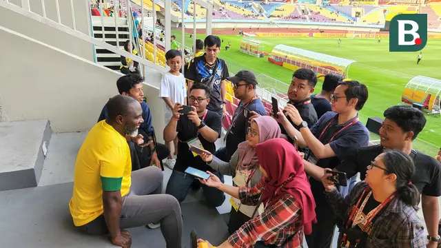 Jacksen F Tiago yang menyaksikan pertandingan babak 16 besar Piala Dunia U-17 2023 antara Ekuador melawan Brasil di Stadion Manahan, Solo, Senin (20/11/2023), mendapatkan serbuan dari penonton untuk berfoto bersama. (Bola.com/Radifa Arsa)
