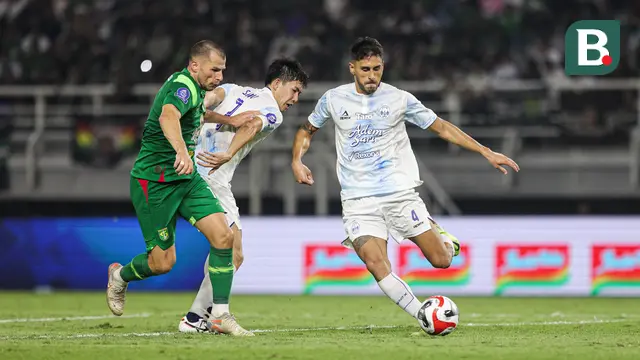 Pemain PSIM Yogyakarta, Franco Ramos Mingo (kanan) mencoba mengamankan bola dari kejaran pemain Persebaya Surabaya, Mihailo Perovic pada BRI Super League 2025/2026 di Stadion Gelora Bung Tomo, Surabaya, Jumat (8/8/2025). (Bola.com/Abdul Aziz) 