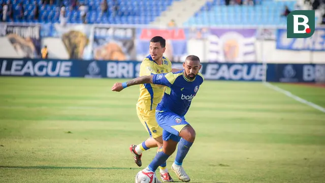 Striker Arema FC, Dalberto mempertahankan bola dari kejaran gelandang Persib Bandung, Thom Haye dalam laga pekan keenam BRI Super League 2025/2026 di Stadion Kanjuruhan, Kabupaten Malang, Senin (22/9/2025). (Bola.com/Iwan Setiawan).
