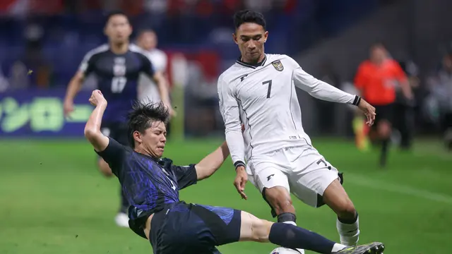 Gelandang Timnas Indonesia, Marselino Ferdinan (kanan) mencoba menghindari adangan pemain belakang Jepang, Kota Takai saat pertandingan putaran ketiga Kualifikasi Piala Dunia 2026 zona Asia grup C antara Jepang dan Indonesia di Osaka pada 10 Juni 2025. (PAUL MILLER/AFP)
