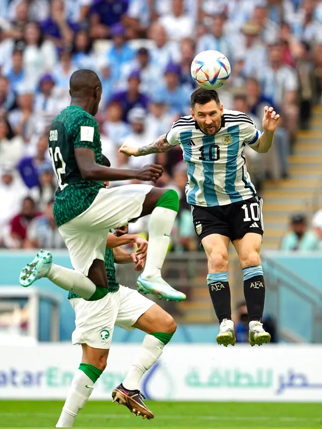 Pemain Argentina Lionel Messi (kanan) berebut bola udara dengan pemain pemain Arab Saudi Saud Abdulhamid pada pertandingan sepak bola Grup C Piala Dunia 2022 di Stadion Lusail, Lusail, Qatar, Selasa (22/11/2022). Arab Saudi mengalahkan Argentina dengan skor 2-1. (AP Photo/Ebrahim Noroozi)