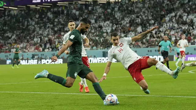 Penyerang Arab Saudi, Saleh Al-Shehri, berusaha mengumpan bola dari kawalan pemain Polandia, Jakub Kiwior, selama pertandingan grup C Piala Dunia 2022 Qatar di Education City Stadium di Al Rayyan, Qatar, Sabtu (26/11/2022). Arab Saudi, meski kalah, masih di peringkat dua dengan tiga poin. (AP Photo/Francisco Seco)