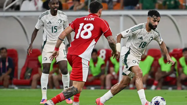 Pemain Arab Saudi, Saleh Abu Alshamat (kanan) berduel dengan Marc Klok dalam pertandingan sepak bola babak keempat Grup B kualifikasi Piala Dunia 2026 di King Abdullah Sports City Stadium, Jeddah, pada Kamis (9/10/2025) dini hari WIB.